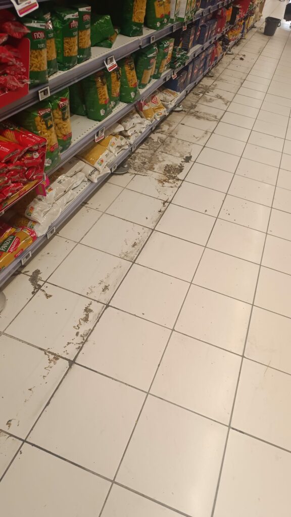 Traces de colle et salissures au sol sous les anciens rayonnages d'un supermarché à Toulouse